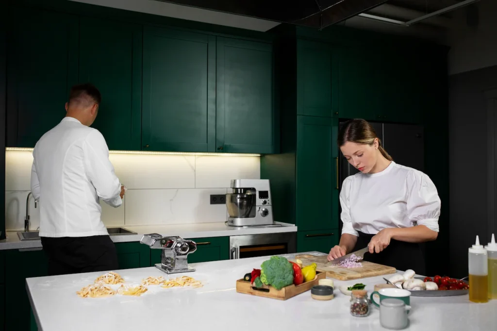 Couple preparing food together in a modern kitchen while chopping vegetables and making fresh pasta